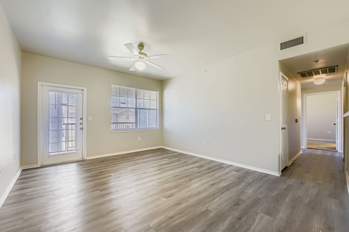 Freshly painted apartment living room with cream walls and wood floors